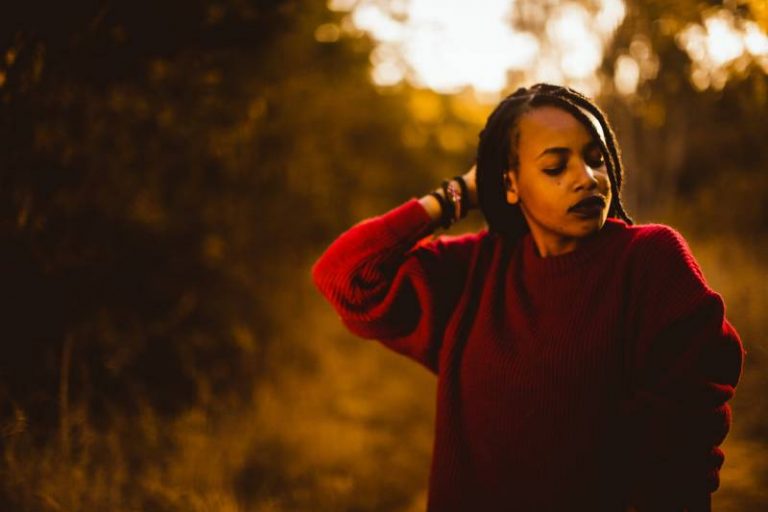 femme touchant ses cheveux avec les yeux fermés